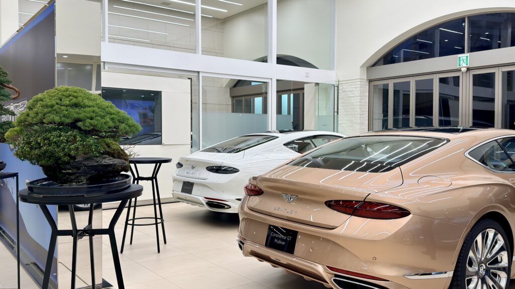 ベントレー名古屋のショールームに展示した盆栽と英国車のリアビューが並ぶ様子